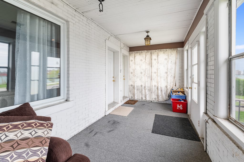 Enclosed main-floor porch with windows along the river-facing side
