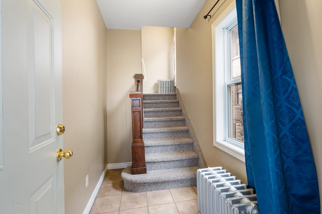 Interior stair hall with original newel post and radiator