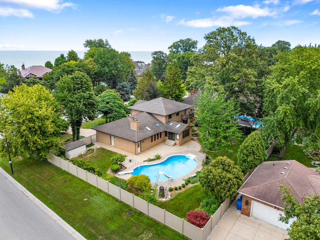 Aerial view of 267 Elmgrove Drive showing the house, in-ground pool, corner lot, and Lake St. Clair beyond
