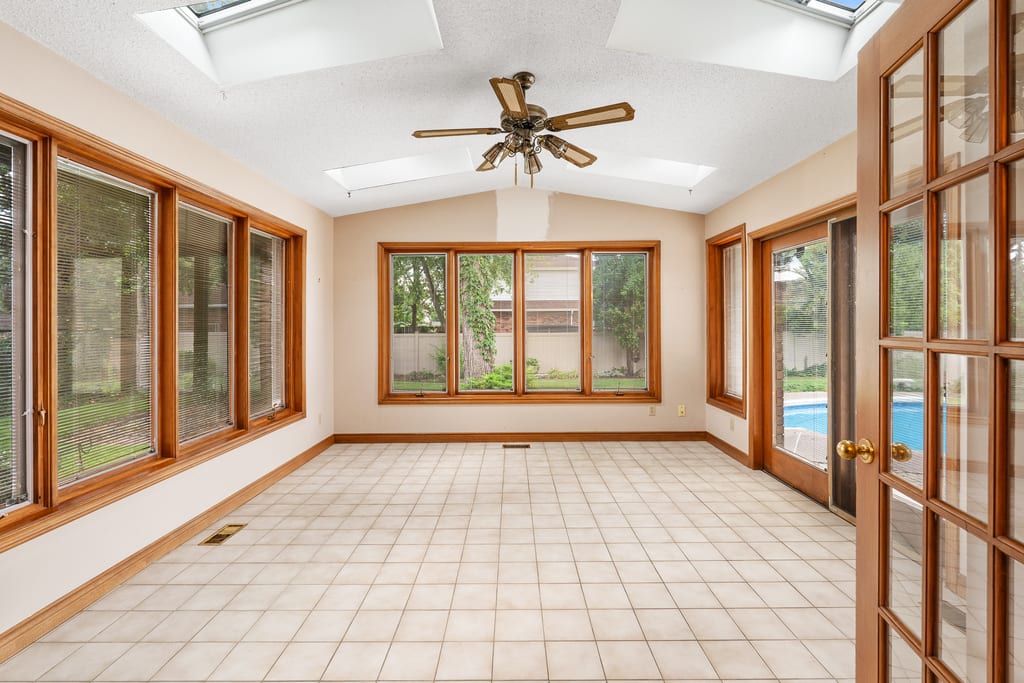 Vaulted four-season room with skylights and windows down both sides overlooking the pool