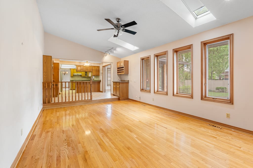 Vaulted family room with hardwood floors and open sightlines through to the kitchen