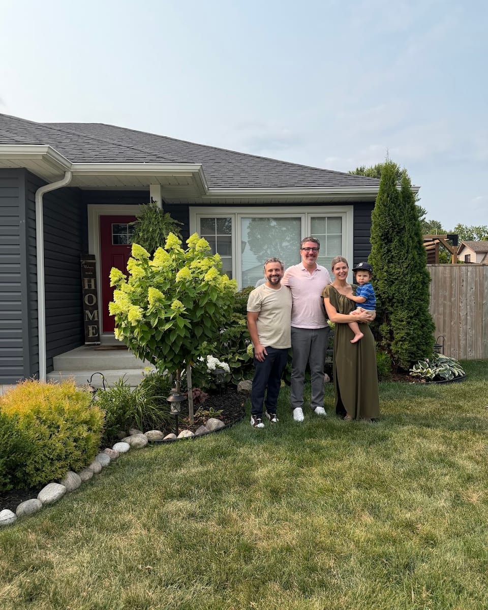 A family with their young child outside their home in Windsor-Essex