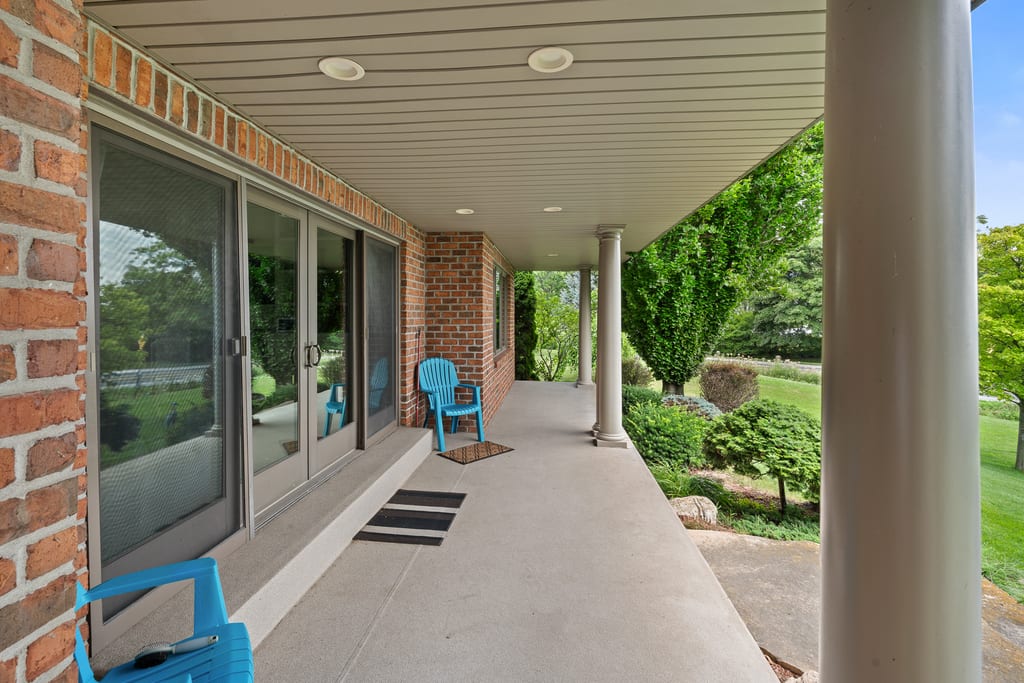 Covered porch running along the back of the house with sliding doors and columns