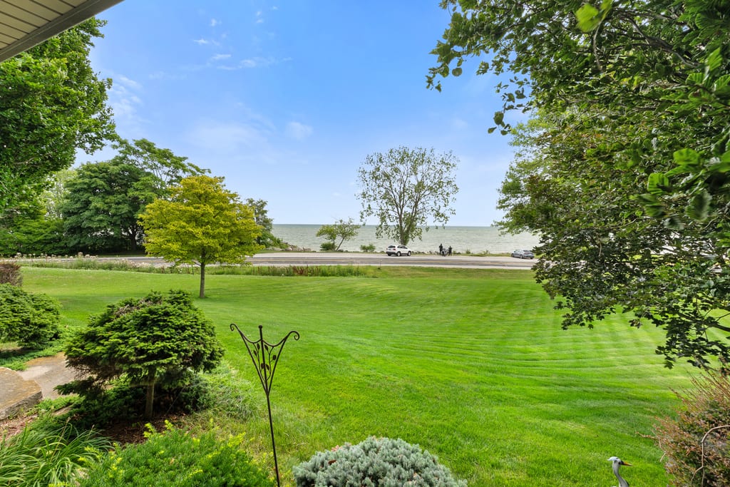 Wide lawn with mature trees running down toward the Lake Erie shoreline