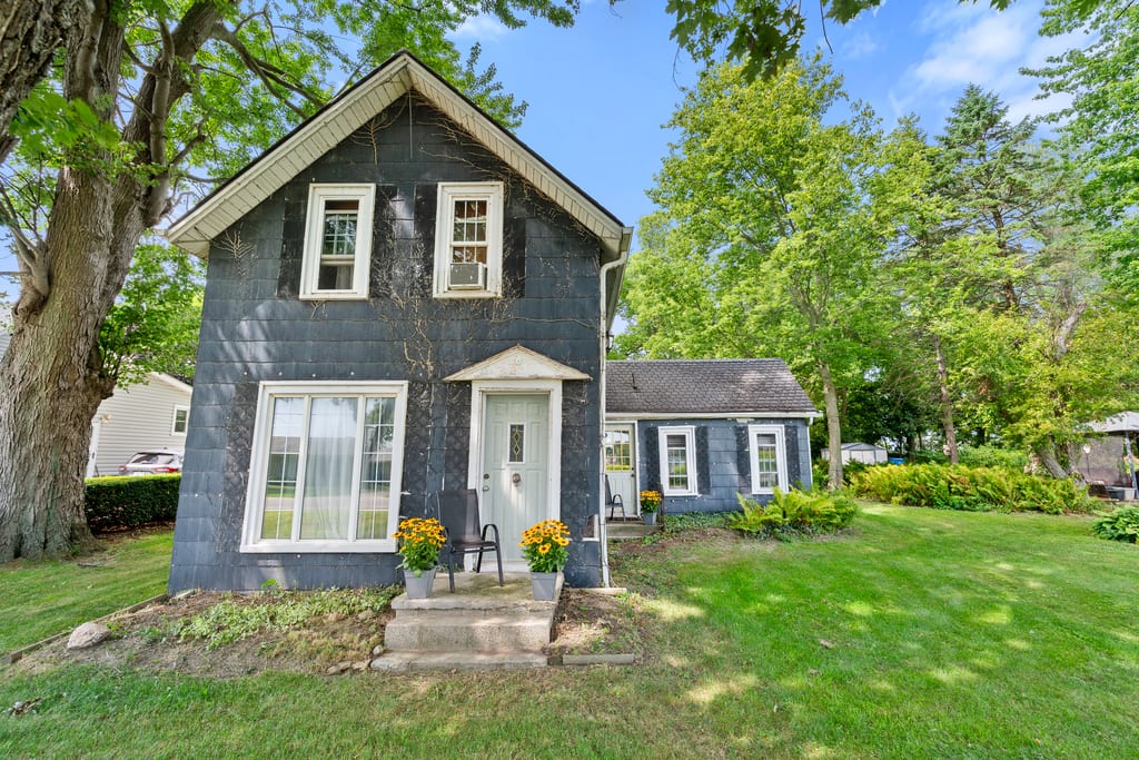 Blue-grey country house at 506 County Rd 50 East beneath a large mature tree