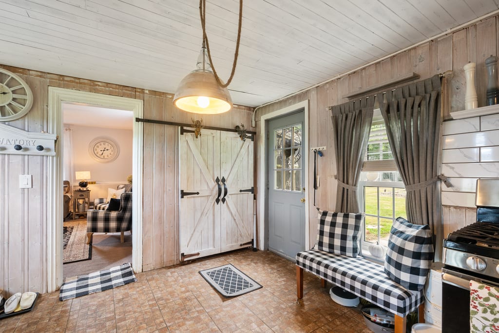 Rear entry with sliding barn doors, tile floor, and a window to the yard