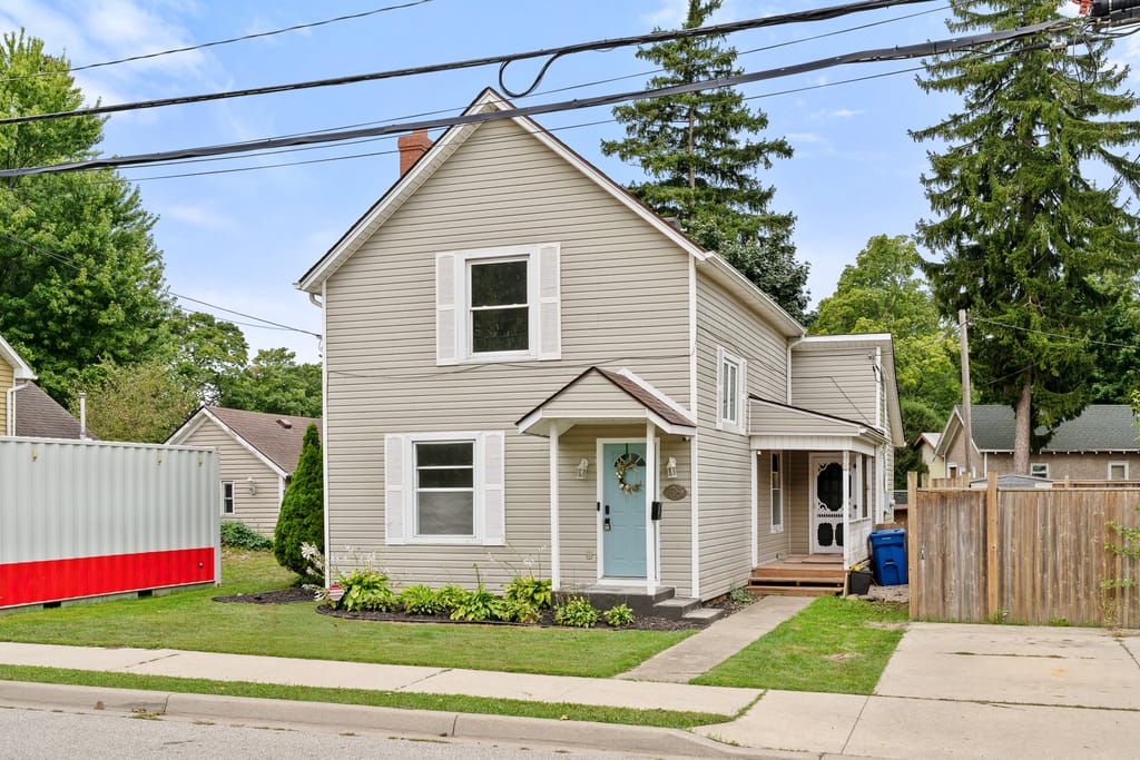 Two storey vinyl-sided house at 58 McDonald Street with a pale blue front door and white shutters