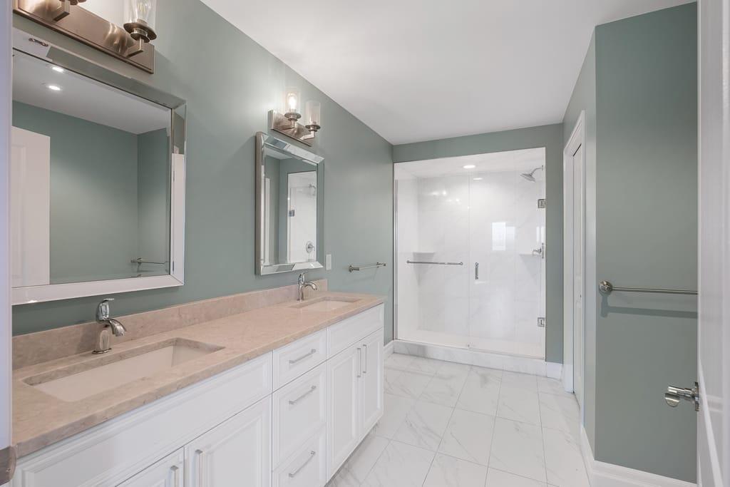 Ensuite bathroom with a long vanity, two mirrors, and a glass walk-in shower