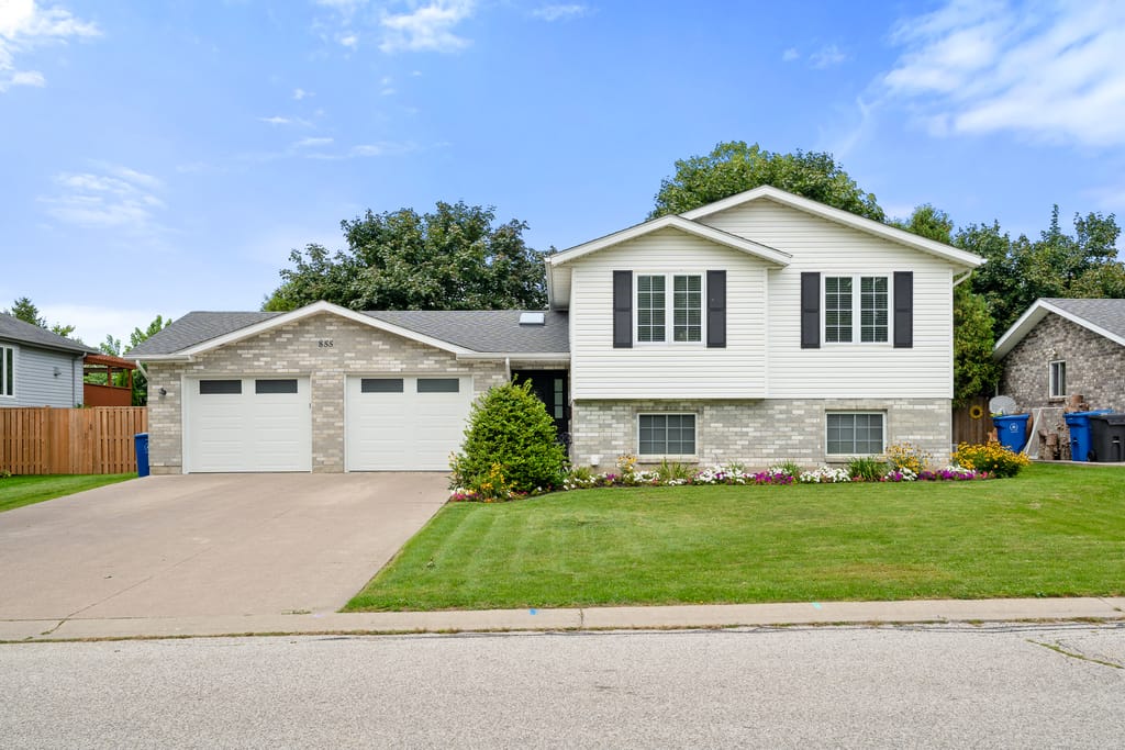 Split level home at 855 Lawndale Avenue with a brick and white siding front, black shutters, and a double garage
